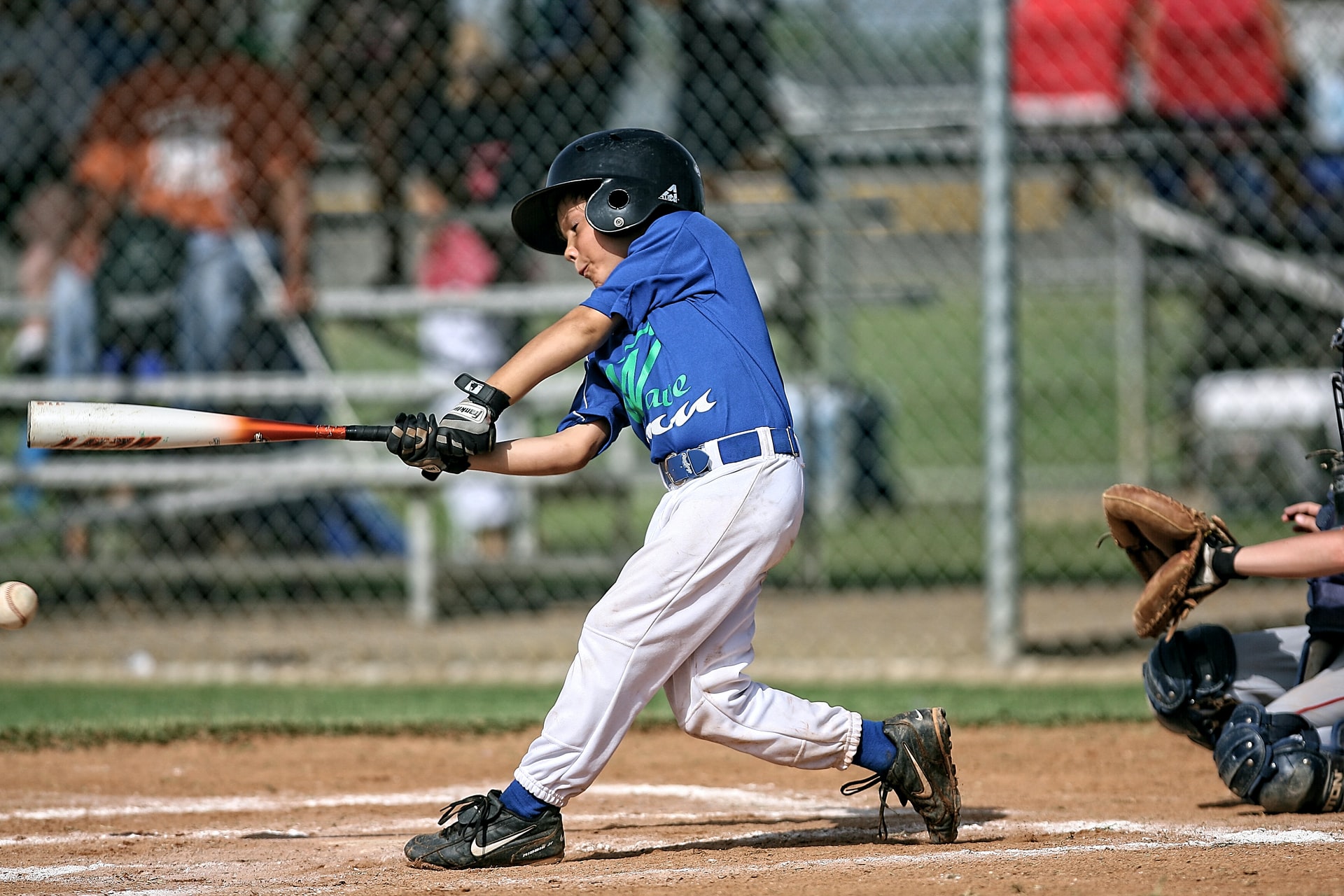 Little League baseball player connects with a pitch