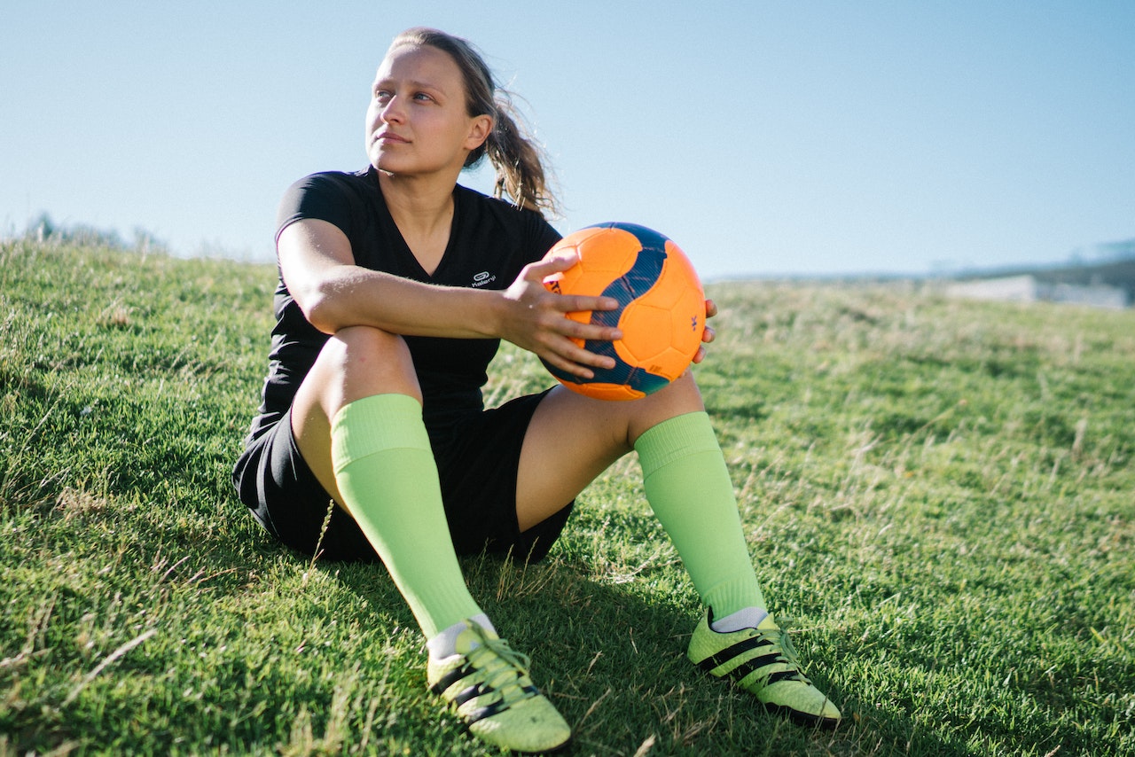 woman football player sitting on the field